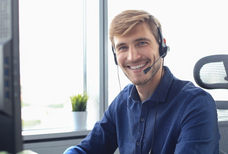 Mann mit Headset lächelnd vor PC